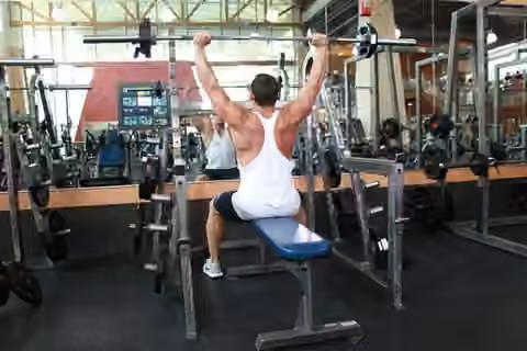 Demonstrasi gerakan Seated Barbell Military Press.