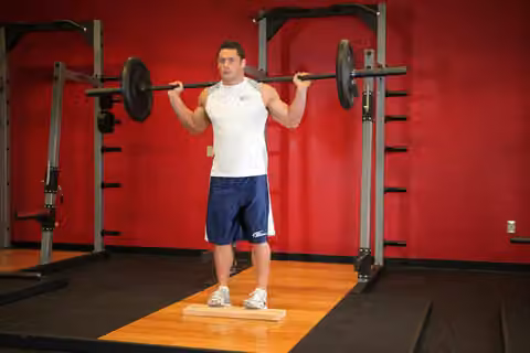 Demonstrasi gerakan Standing Barbell Calf Raise.