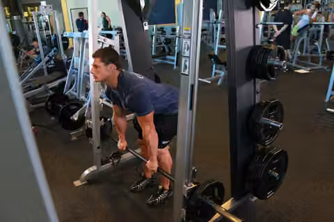 Demonstrasi gerakan Smith Machine Stiff-Legged Deadlift.