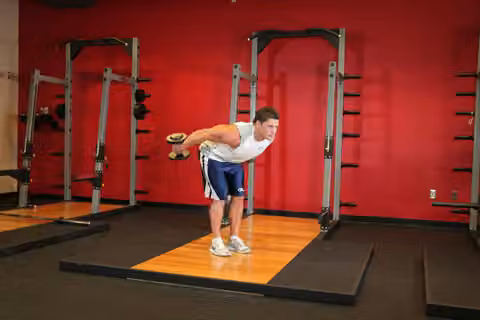 Demonstrasi gerakan Standing Bent-Over Two-Arm Dumbbell Triceps Extension.